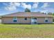 Neutral colored home with a large backyard featuring a glass sliding door and green grass at 1883 Sw 160Th Pl, Ocala, FL 34473