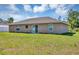 View of the backyard of the home featuring a glass sliding door, green grass and neutral color at 1883 Sw 160Th Pl, Ocala, FL 34473