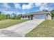 Beautiful home featuring a paved driveway leading to an attached two-car garage and well-manicured lawn at 1883 Sw 160Th Pl, Ocala, FL 34473