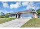 Lovely home featuring a paved driveway leading to an attached two-car garage and well-manicured lawn at 1883 Sw 160Th Pl, Ocala, FL 34473