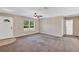 Bright living room with a ceiling fan, natural light, and neutral carpet creating a cozy and inviting space at 1883 Sw 160Th Pl, Ocala, FL 34473
