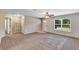 Spacious living room with neutral walls, a ceiling fan, and a view of the front yard through a large window at 1883 Sw 160Th Pl, Ocala, FL 34473