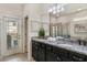 Well-lit bathroom with double vanity, granite counters, and a glass-enclosed shower at 1970 Summer Dr, Davenport, FL 33897