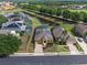 Aerial view of home with solar panels, pond view, and paver driveway at 2142 Victoria Dr, Davenport, FL 33837
