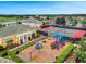 Aerial view of a community with a playground, tennis courts, clubhouse, and well-manicured landscaping at 2142 Victoria Dr, Davenport, FL 33837