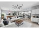 Open concept living room features a modern ceiling fan, and an adjacent kitchen with stainless steel appliances at 2142 Victoria Dr, Davenport, FL 33837