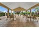 Covered outdoor patio with tables and chairs overlooking the pool and landscaped grounds at 2142 Victoria Dr, Davenport, FL 33837
