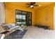 Covered patio features a ceiling fan, rattan sofa, and glimpses of the pool through the sliding glass door at 2142 Victoria Dr, Davenport, FL 33837
