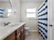 Bright bathroom featuring a vanity with a sink, tile flooring, and a shower with a striped curtain at 216 S Holly Ave, Sanford, FL 32771