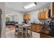 Open kitchen flows to living area, featuring an island, tile floors and wood cabinets at 216 S Holly Ave, Sanford, FL 32771