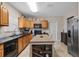 Bright kitchen with wood cabinets, a central island with a wine rack, and stainless steel appliances at 216 S Holly Ave, Sanford, FL 32771