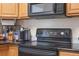 The kitchen boasts an electric range and microwave with wooden cabinetry and dark countertops at 216 S Holly Ave, Sanford, FL 32771