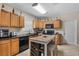 Functional kitchen featuring wood cabinets, black countertops, and an eat-in island at 216 S Holly Ave, Sanford, FL 32771
