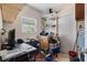 Cluttered home office with a desk, shelves, and storage, illuminated by natural light through a window at 216 S Holly Ave, Sanford, FL 32771