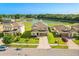Aerial front view of home with landscaped lawn, a large pond and fountain in the backyard at 2211 Wadeview Loop, St Cloud, FL 34769