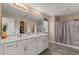 Bathroom featuring double sinks, ample countertop space, and a shower with modern fixtures at 2211 Wadeview Loop, St Cloud, FL 34769