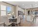 Open-concept dining area with a modern kitchen view, featuring a dark wood table and lots of natural light at 2211 Wadeview Loop, St Cloud, FL 34769