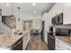 Modern kitchen with white cabinets, stainless steel appliances, granite countertops, and stylish pendant lighting at 2211 Wadeview Loop, St Cloud, FL 34769