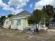 Exterior view of a yellow, one-story home with a side yard and visible peeling paint at 232 S Clara Ave, Deland, FL 32720