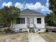 Exterior view of a white, one-story home with a small front yard and metal security gate at 232 S Clara Ave, Deland, FL 32720