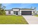 Charming single-story home featuring a well-manicured lawn, a gray garage door and black trim at 236 Marion Oaks Mnr, Ocala, FL 34473