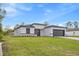 Charming single-story home featuring a well-manicured lawn, a gray garage door and black trim at 236 Marion Oaks Mnr, Ocala, FL 34473