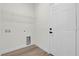 Bright laundry room with wood-look floors, white walls, a wire rack, and hookups for a washer and dryer at 236 Marion Oaks Mnr, Ocala, FL 34473