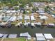 Serene aerial view of waterfront homes with covered boat slips and lush landscaping at 25931 Azalea Ln, Astatula, FL 34705