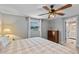 Bright and airy bedroom with soft bedding, wood ceiling fan, and a glimpse of the ensuite bathroom at 25931 Azalea Ln, Astatula, FL 34705