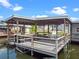 Covered boat dock featuring a wooden deck and space for outdoor seating overlooking the water at 25931 Azalea Ln, Astatula, FL 34705