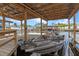 Covered boat dock featuring a boat lift and wooden deck with space for boat parking at 25931 Azalea Ln, Astatula, FL 34705