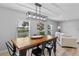 Well-lit dining room featuring a rustic wood table, black chairs, and light, modern flooring at 25931 Azalea Ln, Astatula, FL 34705