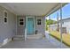 Inviting front entrance featuring a light blue door, gray siding, and covered entry at 25931 Azalea Ln, Astatula, FL 34705