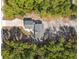 Birds eye aerial view of a single-Gathering home surrounded by trees and a driveway in full sun at 2613 Howland Blvd, Deltona, FL 32738