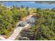Aerial view of a single-Gathering home surrounded by lush trees with beautiful lake views at 2613 Howland Blvd, Deltona, FL 32738