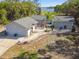 Aerial view of a single-Gathering home with a driveway, well manicured landscaping, and partial lake views at 2613 Howland Blvd, Deltona, FL 32738