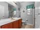 Bathroom featuring a large mirror, wood vanity, and a combination shower-tub with tile floors at 2837 Drifting Lilly Loop, Kissimmee, FL 34747