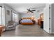 Spacious bedroom with wood floors, a ceiling fan, large windows, dresser and an armchair at 2837 Drifting Lilly Loop, Kissimmee, FL 34747