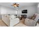 Comfortable living room featuring tile floors, a ceiling fan, and a cozy seating arrangement at 2837 Drifting Lilly Loop, Kissimmee, FL 34747