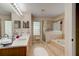 Bright bathroom with double vanity, a soaking tub, and glass-enclosed shower at 2951 E Waco Dr, Deltona, FL 32738