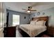 Well-lit bedroom featuring a ceiling fan, dark wood furniture, and a window providing natural light at 2951 E Waco Dr, Deltona, FL 32738