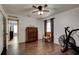 Bedroom with wood-look tile floors, ceiling fan, dresser, and exercise bike at 2951 E Waco Dr, Deltona, FL 32738