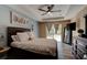 Comfortable main bedroom with tray ceiling, fan, sliding glass door to the outside, and dark wood furniture at 2951 E Waco Dr, Deltona, FL 32738