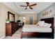 Spacious main bedroom with tray ceilings, dark wood furniture, and a view into the bathroom at 2951 E Waco Dr, Deltona, FL 32738
