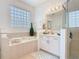 Bathroom featuring a bathtub, glass block window and tiled floors at 2977 White Cedar Cir, Kissimmee, FL 34741