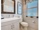 Bathroom featuring decorative tile, a vanity with a framed mirror, and a toilet near the window at 2977 White Cedar Cir, Kissimmee, FL 34741