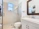 Bright bathroom with a glass shower door, modern vanity with a mirror, and neutral colored tiles at 2977 White Cedar Cir, Kissimmee, FL 34741