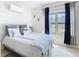 Bedroom featuring a bed with decorative pillows, a large window with blue curtains, and light-colored walls at 2977 White Cedar Cir, Kissimmee, FL 34741