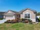 Charming single-story home with a two-car garage, meticulously landscaped front yard, and manicured lawn at 2977 White Cedar Cir, Kissimmee, FL 34741