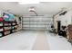 Spacious garage with a clean epoxy floor, overhead door, storage shelves, and ample room for parking at 2977 White Cedar Cir, Kissimmee, FL 34741